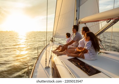 Carefree family travel adventures for young Latino parents with son and daughter relaxing on luxury yacht at sunset