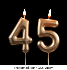 Lilin hari jadi emas menyala diasingkan pada latar belakang hitam, nombor 45