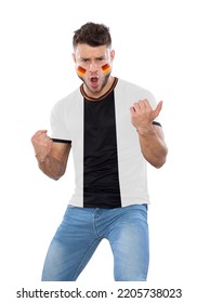 Soccer fan man with black and white jersey and face painted with the flag of the germany team screaming with emotion on white background.
