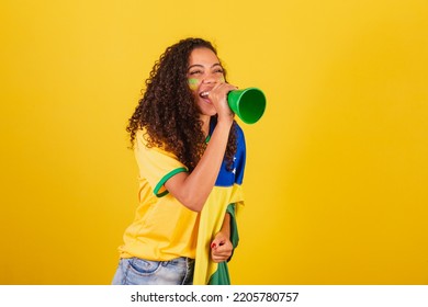 Ung sort brasiliansk kvinde, fodboldfan. skrigende gennem højttaleren. reklamefoto.