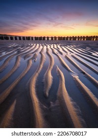 Un paisaje marino durante la puesta de sol. Líneas de arena en la orilla del mar. Cielo brillante durante la puesta de sol. Una playa de arena durante la marea baja. Imagen de viaje. Fotografía para el diseño.