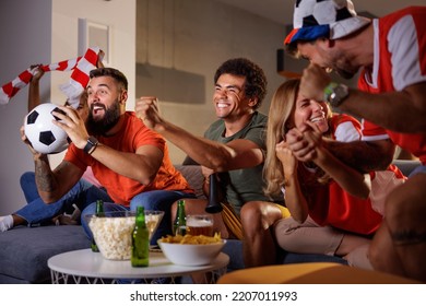 Group of football fans cheering while watching game on TV, celebrating their team scoring a goal and winning the match