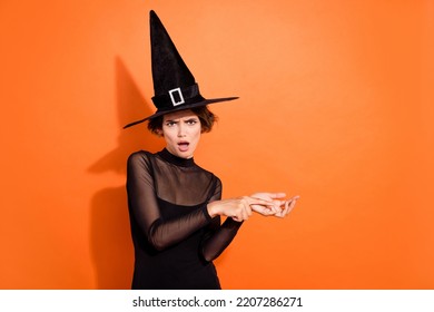 Photo of impressed shocked girl dressed black gothic dress headwear counting fingers empty space isolated orange color background