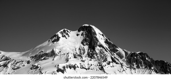 Pemandangan panorama hitam dan putih di gunung bersalju tinggi di musim dingin. Pegunungan Kaukasus, Georgia, wilayah Gudauri, Gunung Kazbek.