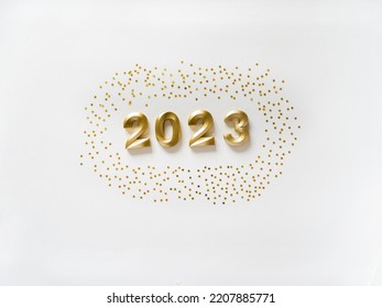 Kartu ucapan - selamat tahun baru dengan angka 2023 dan kilau emas dengan latar belakang putih. Konsep liburan yang cerah. Pandangan atas. Berbaring datar