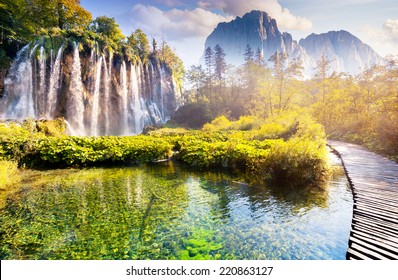 Majestätischer Blick auf Wasserfall mit türkisfarbenem Wasser, sonnige Balken im Nationalpark Plitvicer Seen. Wald leuchtet durch Sonnenlicht. Kroatien. Europa. Dramatische Morgenszene. Schönheitswelt. Kreative Fotocollage