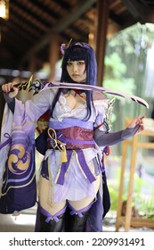 Portrait of a beautiful young woman game cosplay with samurai dress costume on Japanese garden
