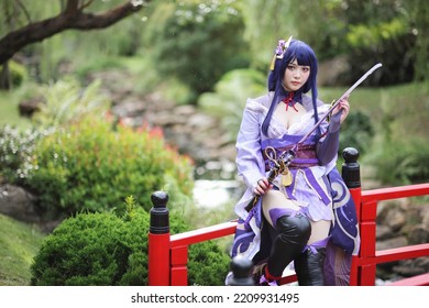Portrait of a beautiful young woman game cosplay with samurai dress costume on Japanese garden