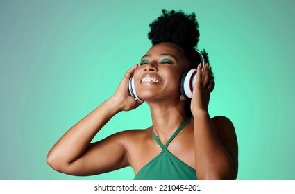 Studio, happy and black woman in headphones with music playing from a Jamaican dance hall and reggae radio audio playlist. Freedom and young African girl enjoying listening fun, streaming and sounds