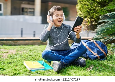 Blond child student smiling confident listening to music at park