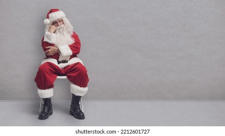 Papai Noel entediado sentado em uma cadeira e esperando por uma entrevista de emprego