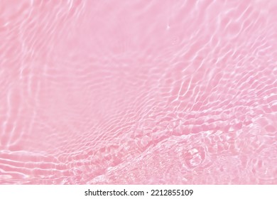 Defocus verschwommene, transparente, rosafarbene, klare, ruhige Wasseroberflächenstruktur mit Spritzer, Blase. Glänzender rosa Wasserkräuselungshintergrund. Wasseroberfläche im Schwimmbad. Rosa Blasenwasser scheint.