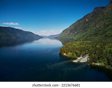 Landscape with boats in the water lake with views of the mountains. Teletskoye Lake Altai in Siberia.