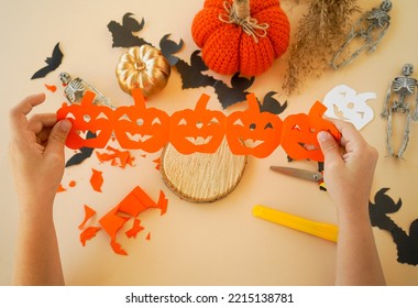 Step-by-step instructions for creating garlands of paper decorations by children for the Halloween holiday. Step 6 unfold the folded strip.