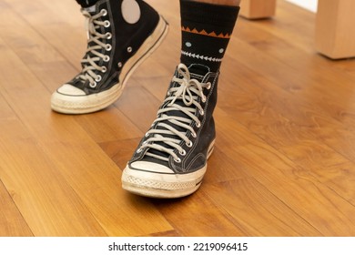Sepatu kets hitam tinggi. Sepatu kasual klasik yang populer di lantai laminasi.