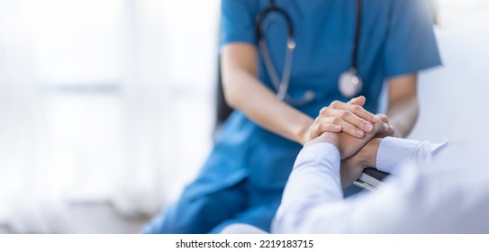 Cropped shot of a female nurse hold her senior patient's hand. Giving Support. Doctor helping old patient with Alzheimer's disease. Female carer holding hands of senior man