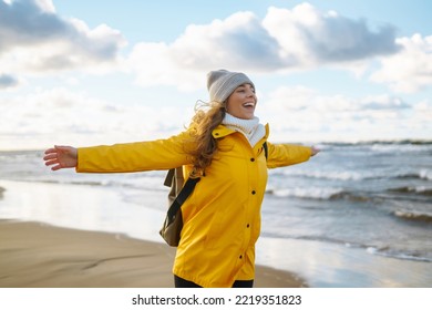 The girl tourist in a yellow jacket posing by the sea. Travelling, lifestyle, adventure.