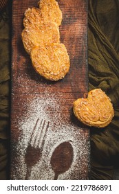 Biskuit palmier - Kue Prancis yang terbuat dari puff pastry (juga disebut daun palem, telinga gajah, atau hati Prancis) di piring di atas meja kayu. Pandangan atas