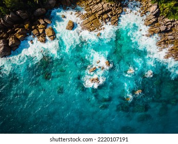 Aerial view Top down seashore. Waves crashing on rock cliff. Beautiful dark sea surface in sunny day summer background Amazing seascape top view seacoast at Intendance Beach, Mahe Seychelles