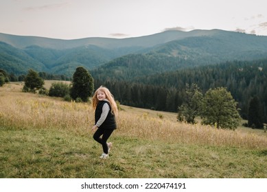 Petite fille randonneuse courant sur l'herbe dans les montagnes d'automne. Concept de voyage. Vacances, voyage et vacances. Journée mondiale du tourisme. Profiter du temps passé en marchant au coucher du soleil au sommet d'une montagne brumeuse. Jeux de plein air actifs.