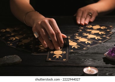 Ghicitorul prezice viitorul cu cărți de tarot la masă în întuneric, cadru apropiat