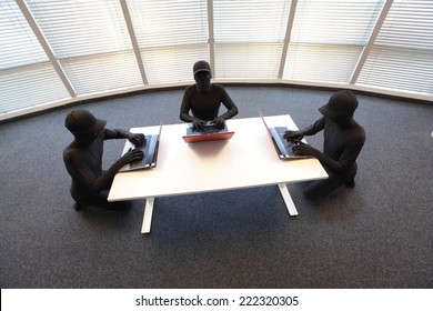groupe de pirates informatiques anonymes en costumes noirs travaillant avec des ordinateurs au bureau