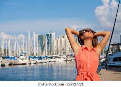 Schöne lächelnde Frau am Strand auf der hawaiianischen Insel Honolulu. Ferienorturlaub. Yachten säumen den Hafen von Ala Moana in der Nähe von Waikiki Oahu Hawaii.