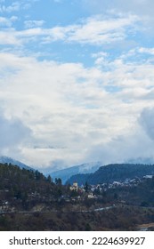 冬の山の風景。山間の小さな町。雲が街にかかっています。