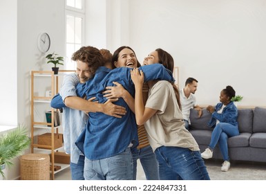 Prietenii fericiți care nu s-au văzut de mult timp se îmbrățișează în timpul întâlnirii acasă. Cei mai buni prieteni, bărbați și femei, râd și se îmbrățișează strâns. Conceptul de reuniune a prietenilor.