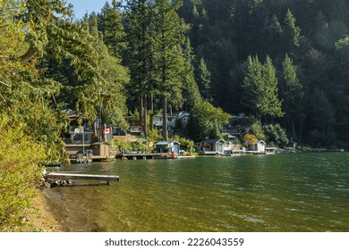 Houses on the shore of forest lake in British Columbia. Wooden houses at the Errock Lake BC Canada. Travel photo, nobody, selective focus-October 12,2022