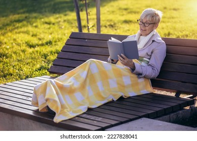 Постарата жена се релаксира во парк со роман