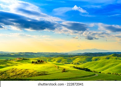 Toskana, ländliche Sonnenuntergangslandschaft. Bauernhof auf dem Land, Zypressen, grüne Wiese, Sonnenlicht und Wolken. Volterra, Italien, Europa.