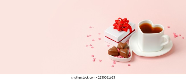 Flat lay of heart shaped cup of black coffee, gift box and candy on pink background with copy space. Valentine's day, beverage concept, Good morning, romance surprise, banner, flyer