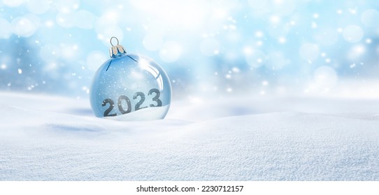 Bola de Navidad de cristal transparente en la nieve con el año 2023