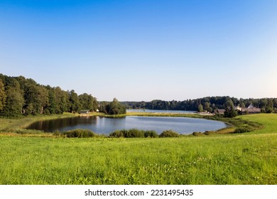 Lago Kaussjärv en el condado de Võru, Estonia. Pequeño lago, hierba verde.