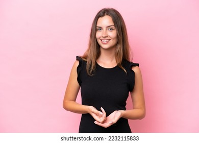 Người phụ nữ da trắng trẻ tuổi bị cô lập trên nền màu hồng đang cười