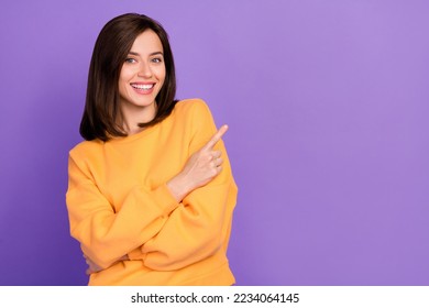 Foto de close-up de uma senhora alegre e elegante com roupas laranja, braço direto, espaço vazio, procedimento de beleza, isolado em fundo de cor roxa