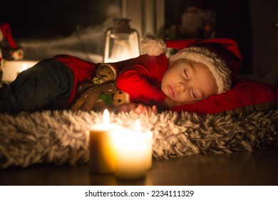 Linda criança, menino, dormindo na véspera de Natal, esperando o Papai Noel chegar e trazer presentes