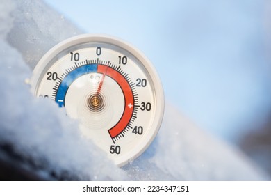 Thermometer met Celsius-schaal in de sneeuw die een omgevingstemperatuur van plus 5 graden aangeeft. Ongewoon hoge winteromstandigheden. Warm winterweer en klimaatveranderingconcept