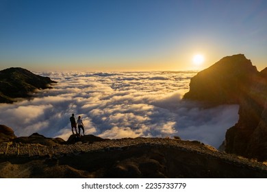 Wanderer bewundern einen atemberaubenden Sonnenuntergang über den Wolken in der Bergkulisse des Pico do Arieiro auf der Insel Madeira in Portugal.