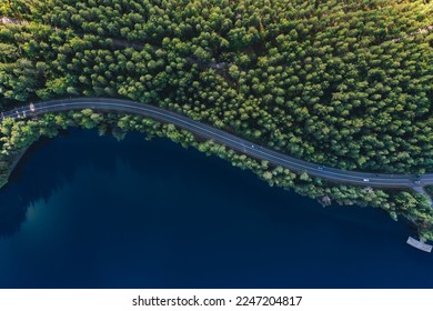 Vue aérienne d'une route avec des bois verts au bord de l'eau des lacs bleus en été en Finlande.