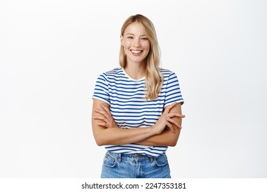 Cô gái xinh đẹp vui vẻ cười và mỉm cười. Người phụ nữ Scandinavia hiện đại tạo dáng trên nền trắng, trông vui vẻ, mặc quần áo mùa hè