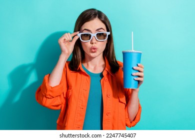 Foto wanita cantik imut yang cantik mengenakan pakaian trendi oranye menikmati waktu luang bersantai film menarik terisolasi pada latar belakang warna cyan
