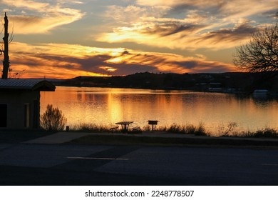 Beautiful sunset sky at Inks Lake State Park Burnet Texas USA.  The cabin, and picnic table on the shore are ready for a family to enjoy the vacation.