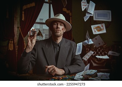 黑手党的犯罪世界。一名身穿优雅黑色西装、头戴白色帽子的强悍黑帮男子坐在豪华公寓里打牌。复古风格。侦探电影。