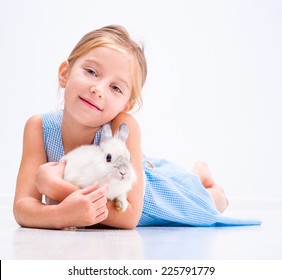 白いウサギと青いドレスでかわいい笑顔の女の子
