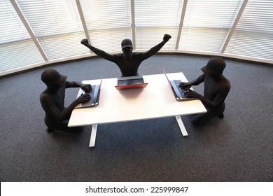 groupe de pirates informatiques anonymes en costumes noirs travaillant avec des ordinateurs au bureau