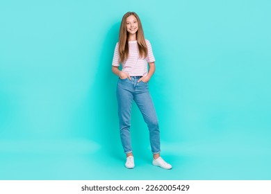 รูปถ่ายเต็มตัวของหญิงสาวน่ารักมีเงาวับสวมเสื้อยืดลายทาง เดิน มือ แขน กระเป๋า พื้นหลังสีฟ้าครามแยกออกมา