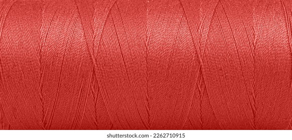 Texture de fils dans une bobine de couleur rouge sur fond blanc en gros plan