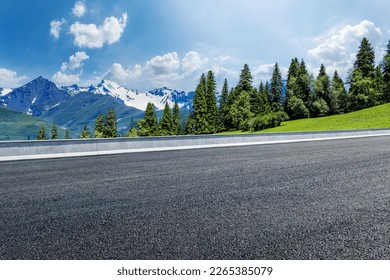 Asphalt road and green forest with mountain natural scenery in Xinjiang, China.